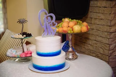 Multilevel wedding cake on white table. Sweets in white and blue colour Stock Photos