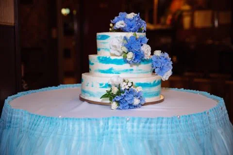 Multilevel wedding cake on white table. Sweets in white and blue colour Stock Photos