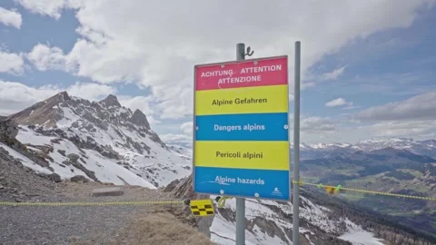 Multilingual alpine hazard sign warns hikers of mountain dangers Stock Footage 310077455