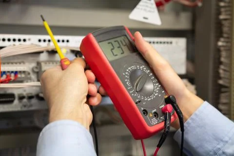 Multimeter in electrician hands. Engineer working in electrical circuits. Stock Photos
