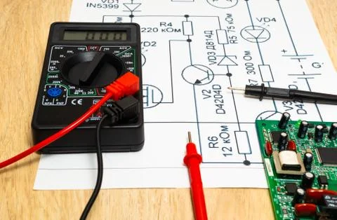 Multimeter probes examining a computer circuit board and circuit. Stock Photos