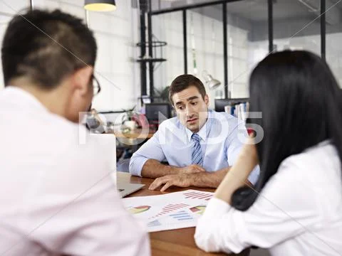 Multinational businesspeople discussing sales performance in office Stock Photos