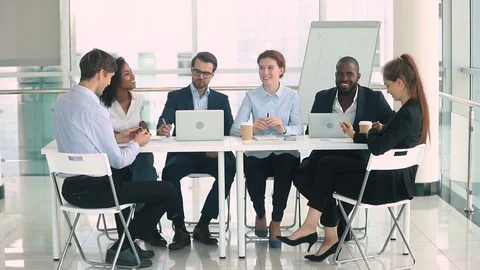 Multinational businesspeople sitting at table negotiating brainstorming discuss Stock Footage 113289751