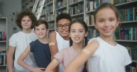 Multinational children stand in library after vaccination Stock Footage 185141788