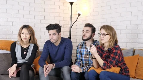 Multinational company sit on the couch and watch some video, doing facepalm Video stock 82412020