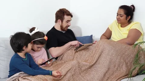 Multinational family spending time on sofa with mobile devices Stock Footage 148843221