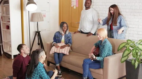 Multinational group eats pizza indoor and talk at home Stock Footage 89374890
