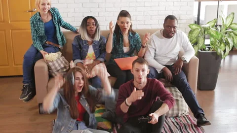 Multinational group of young friends is playing a tv game Stock Footage 89417423