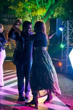 Multinational night party funny people dancing at outdoor dance floor with .. Stock Photos