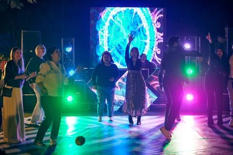 Multinational night party funny people dancing at outdoor dance floor with .. Stock Photos