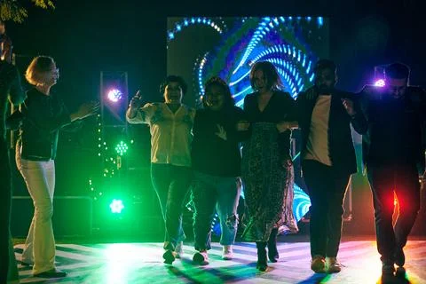 Multinational night party funny people dancing at outdoor dance floor with .. Stock Photos