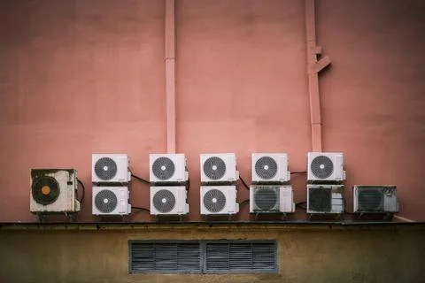 Multiple air conditioners on a textured colored wall Stock Photos