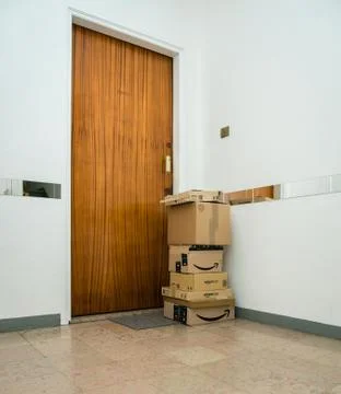 Multiple Amazon Prime cardboard parcels near apartment door Stock Photos