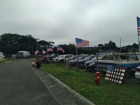 Multiple American flags displayed on a fence Фото