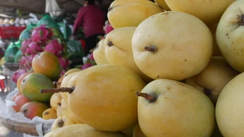 Multiple baskets of ripe mangoes fill the market stall, piled high and exposed Stock Footage 308870636