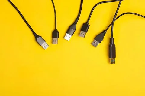 Multiple black usb cables on yellow background Stock Photos