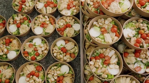 Multiple bowls of fresh salad with chicken, cherry tomatoes, croutons, and Stock Footage 340172388