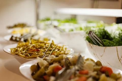 Multiple bowls hold various fresh vegetables and salad ingredients on a buffe Stock Photos