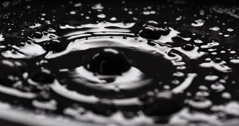 Multiple bubbles of dark, shiny substance bursting on surface Stock Footage 104159493