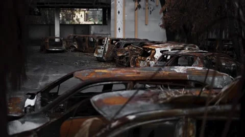 Multiple burned vehicles piled in destroyed structure 库存影片 345860516