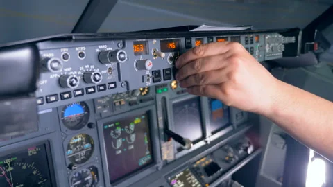 Multiple buttons on a plane's console are being pushed and rotated by a pilot Stock Footage 90756181