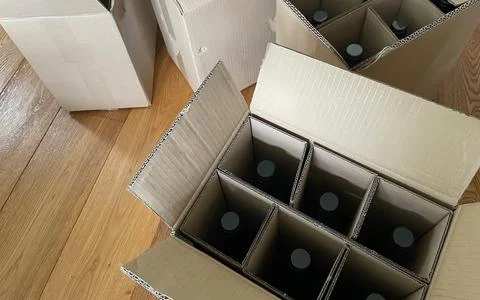 Multiple cardboard boxes filled with bottles ready for shipping and delivery Stock Photos