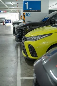 Multiple cars parked in modern indoor parking garage. Organized vehicle sto.. Stock Photos