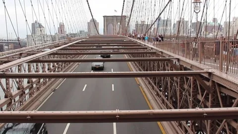 Multiple cars passing under the 3 lanes of traffic under the Brooklyn Bridge 库存影片 149240053