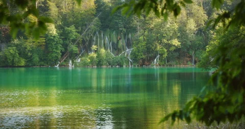 Multiple cascading waterfalls into emerald lake in Plitvice Lakes National Park Stock Footage 308261130