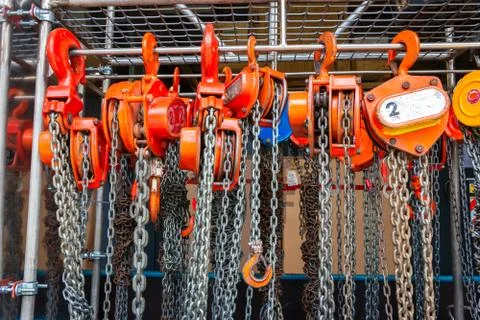 Multiple chain hoists hanging in a rack Stock-Fotos