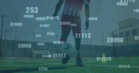Multiple changing numbers against male soccer player juggling the ball on grass Stock Photos