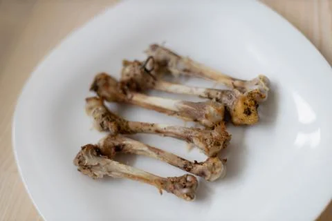 Multiple chicken bones on a white plate Photos