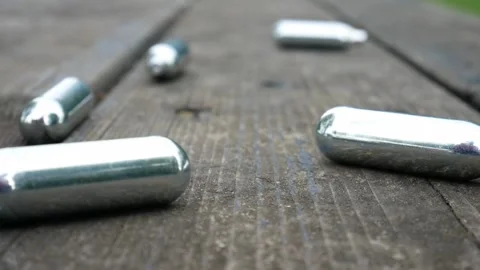 Multiple chrome nitrous oxide laughing gas drug cylinders Stock Footage 133364006