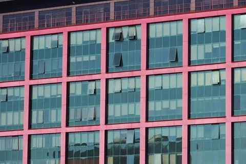 Multiple closed windows on a large office building. Stock Photos