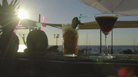 Multiple cocktails on a bar with sun setting into the sea in the background Stock-Footage 140050298
