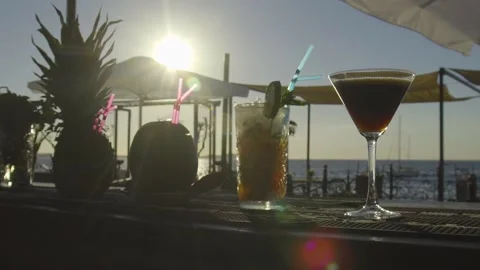 Multiple cocktails on a bar with sunset and sea in the background Stock Footage 140049952