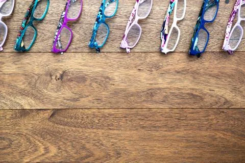 Multiple colored eye glasses lined on wooden deck.  Eye Health Concept. Top V Stock Photos