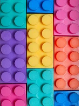 Multiple colored plastic building blocks on a gray textured background 스톡 사진