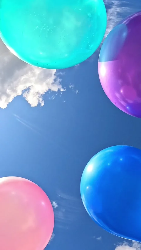 Multiple colorful balloons drifting across blue sky with clouds Stock-Footage 318165468
