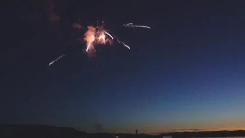 Multiple colorful fireworks bursting in sequence over twilight ocean Stock Footage 340632703