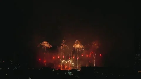 Multiple colorful large fireworks Mines Bursting Over night City in the Stock Footage 343045010