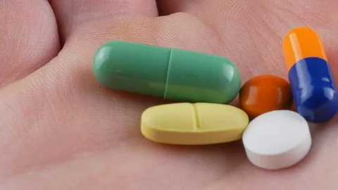 Multiple colors pills in hand , Taking Your Medication. Stock Footage 100194953