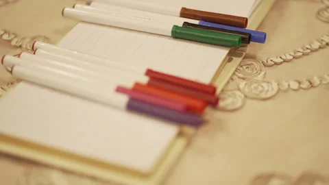Multiple colourful pens on book. Stock Footage 247359688