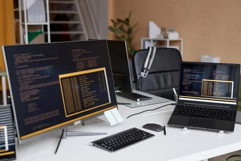Multiple Computer Devices with Code Lines on Screen in IT Development Office Foto stock