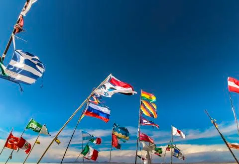Multiple country flags against the wind at Plaza de las Banderas Uyuni Stock Photos