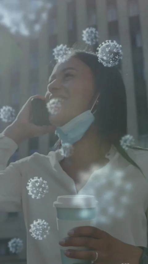 Multiple covid-19 cells floating against woman with lowered face mask talking on Stock Footage 331646424