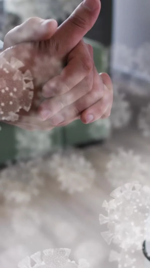 Multiple covid-19 cells floating over mid section of man using hand sanitizer at Stock Footage 344635680