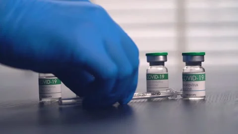 Multiple COVID-19 vaccine vials placed on a laboratory table Stock Footage 153068349
