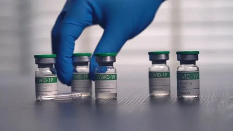 Multiple COVID-19 vaccine vials placed on a laboratory table Stock Footage 153068350