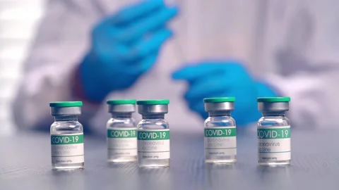 Multiple COVID-19 vaccine vials placed on a laboratory table Stock Footage 153068452